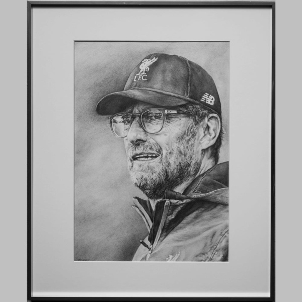 Tauchen Sie ein in die beeindruckende Welt der Kunst mit der fotorealistischen Bleistiftzeichnung "Jürgen Klopp" von Künstlerin Karin Engel. Auf einer Fläche von 60 x 50 cm fängt Engel mit feinem Bleistift die charakteristischen Züge des Trainers Jürgen Klopp detailgetreu ein. Das Kunstwerk ist in einem staubdichten schwarzen Holzrahmen mit säurefreiem Passepartout gerahmt, was die Eleganz der Darstellung unterstreicht. Ein Meisterstück der Porträtkunst, das Klopps Persönlichkeit und Ausstrahlung meisterhaft einfängt.